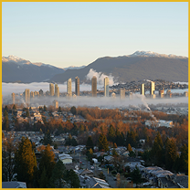 City skyline above autumn trees and morning fog