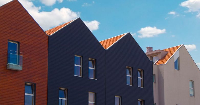 Colorful modern townhouses with gabled roofs under blue sky