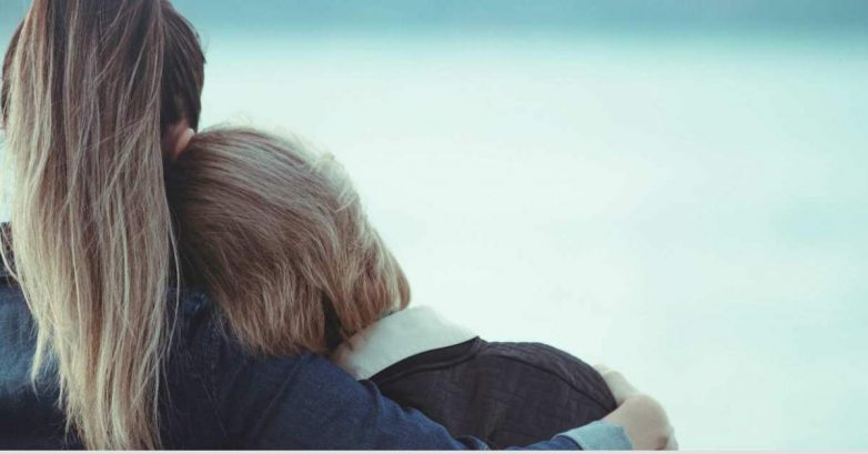 Two people embracing, viewed from behind