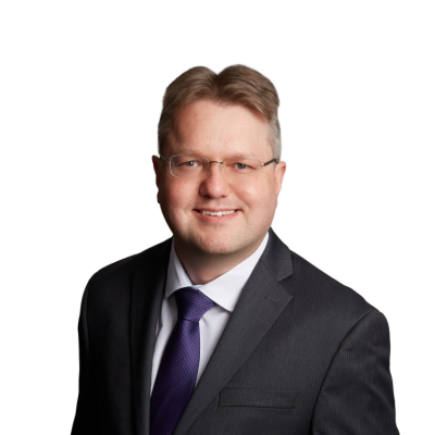 Professional headshot of man in suit and glasses