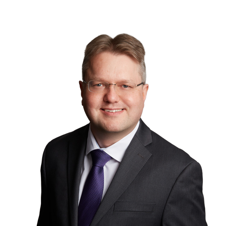 Professional headshot of man in suit and glasses
