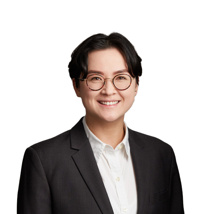Professional headshot of smiling person in suit and glasses