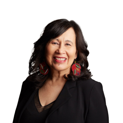 Smiling woman in black blazer with colorful earrings