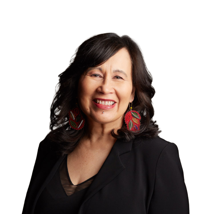 Smiling woman in black blazer with colorful earrings